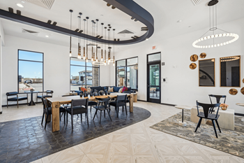 A modern dining room with a large table and chairs.